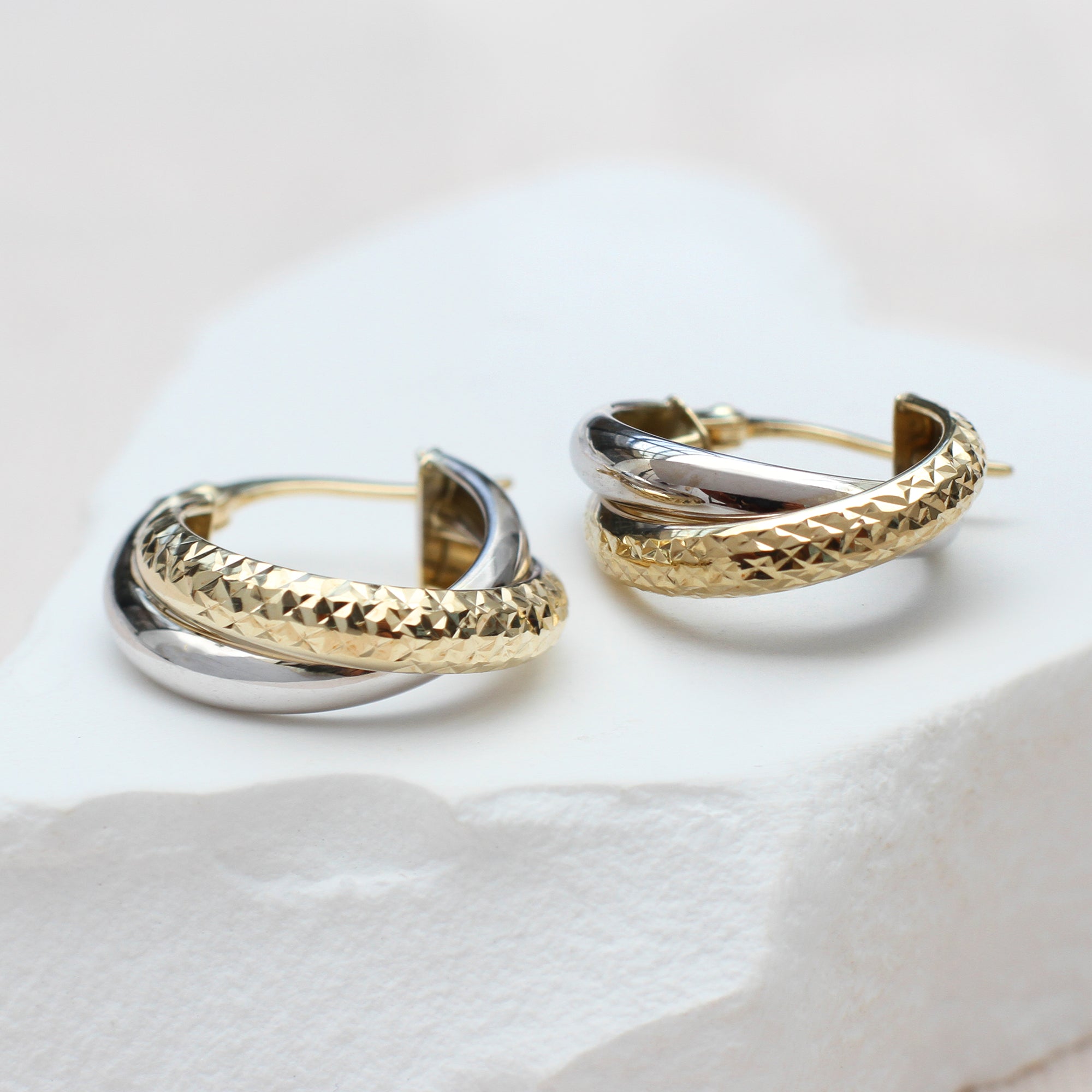 9ct-Two-Tone-Gold-Diamond-Cut-And-Plain-Band-Crossover-Hoops.jpg